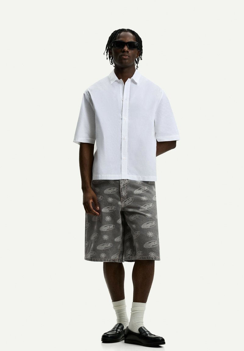 White short-sleeve button-up shirt paired with gray patterned shorts featuring a digital print, black loafers, and white socks.