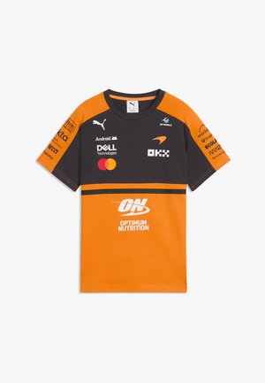 Kortærmet racingteam-trøje i sort og orange med flere sponsorlogoer, herunder Puma, Dell, Mastercard og Optimum Nutrition.