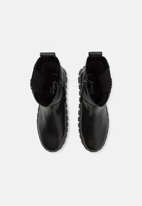 Schwarze Ankle Boots aus glattem Leder, mit elastischen Seitenpaneelen, einem Reißverschluss und strukturierten Gummisohlen für einen besseren Halt.