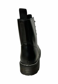 Botín negro de cuero con un acabado suave, suela plana y costuras blancas. Cuenta con una asa en la parte posterior y cordones redondos.