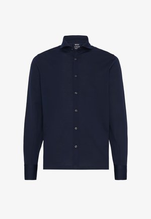 Mornarsko srajco z dolgimi rokavi iz lahkotnega materiala, z gumbi na sprednji strani, koničastim ovratnikom in kontrastnimi gumbi ob zaplatu.