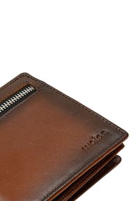 Brązowy skórzany portfel z zamykaną na zamek kieszenią, widocznym przeszyciem, gładką fakturą i wytłoczonym logo na powierzchni.