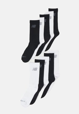 Baumwoll-Trainingssocken in Schwarz und Weiß, die ein Logo oben aufweisen. Jedes Paar hat einen gerippten Bund und eine glatte Textur.