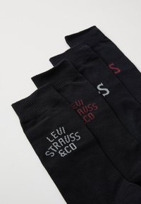 Tre par sorte bomuldsstrømper med ribbede manchetter, der har trykte "Levi Strauss & Co" logoer i grå og bordeaux på siderne.