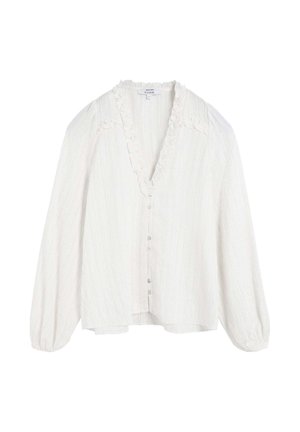 Blusa blanca texturizada con escote en V, cuello con volantes y mangas largas abullonadas. Cuenta con un cierre frontal de botones y un dobladillo ligeramente asimétrico.