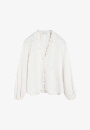 Blusa blanca texturizada con escote en V, cuello con volantes y mangas largas abullonadas. Cuenta con un cierre frontal de botones y un dobladillo ligeramente asimétrico.