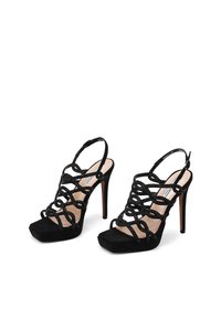 Sandali con tacco alto neri, con cinghie superiori incrociate, caratterizzati da una texture in suede e un motivo decorativo. Design a punta quadrata, con retro aperto.