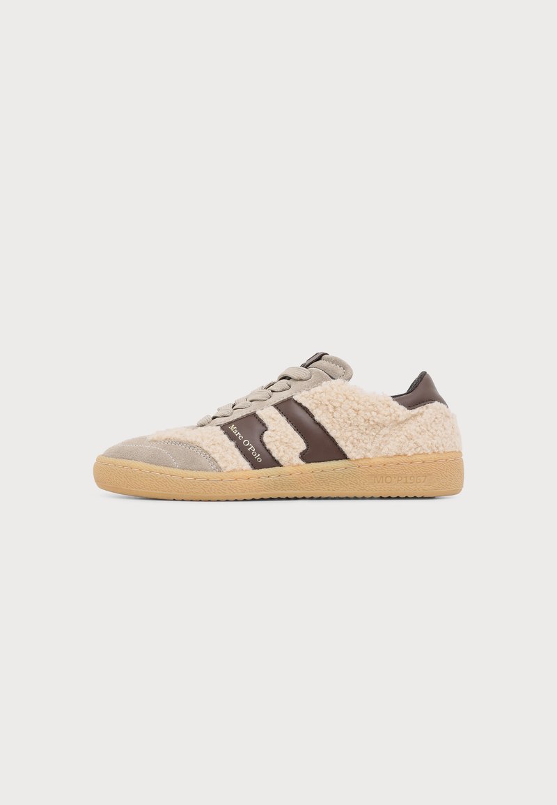 Χαμηλό sneaker με υφή μπεζ shearling, καφέ δερμάτινες λεπτομέρειες, ανοιχτό καφέ σόλα και μπεζ κορδόνια, πλευρική όψη σε μονόχρωμο φόντο.