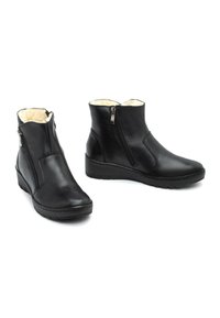 Czarne skórzane botki za kostkę z bocznym zamkiem, miękkim kremowym wykończeniem, koturnem oraz teksturowaną podeszwą dla lepszej przyczepności.