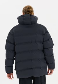 Pufferjacke in dunkelblau, mit hohem Kragen, gestepptem Muster und elastischen Bündchen. Das Design ist oversized mit einer lockeren Silhouette.