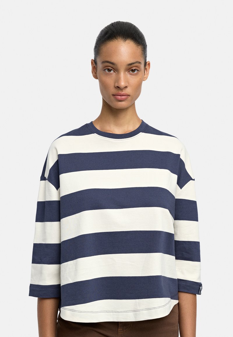 Sweter bawełniany w paski w kolorze granatowym i białym, z okrągłym dekoltem i rękawami do łokcia. Posiada luźny krój i widoczne detale szwów.