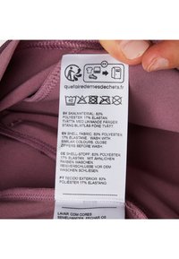 Purple fabric with a smooth texture, accompanied by a care label in multiple languages detailing material composition and washing instructions.
