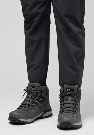 Graue Wanderschuhe aus strukturiertem Mesh und synthetischen Materialien, mit verstärkten Knöcheln, stabilen Schnürsenkeln und einer gemusterten Sohle für besseren Halt.