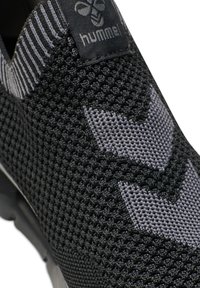Black and gray sneaker with a breathable mesh texture and patterned design. Features a logo tag on the tongue and elastic collar for easy wear.