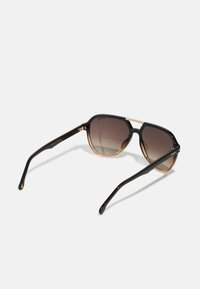 Ochelari de soare cu un cadru din plastic negru și maro degradat, lentile supradimensionate și tempori subțiri negri cu accente aurii.