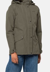 Olivgrön vattentät jacka med huva, tryckknappar, sidofickor och justerbara ärmar, med en slät yta och enkel design.