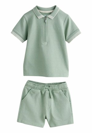 Weiches grünes Kurzarm-Poloshirt mit Reißverschlusskragen und passenden elastischen Taillenshorts mit Kordelzug und Seitentaschen.