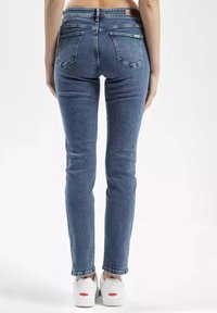 Chude niebieskie dżinsy wykonane z denimu, z klasycznym pięciopocketowym wzornictwem, detalami ściegów i średnim stanem pasa.