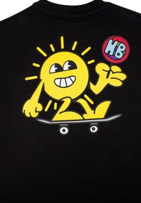 Čierne tričko s potlačou žltého karikatúrneho slnka na skateboarde s lízatkom, usmievajúce sa, s grafickými detailmi a farebnými akcentmi.