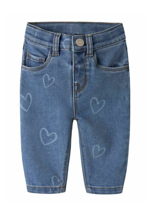 Blå denim babybukser med syede lommer, knaplukning, bæltestropper og lyse hjerte mønstre på stoffet.