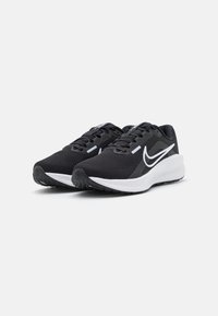 Schwarze Sportchuhe mit einem strukturierten Mesh-Obermaterial, weißem Swoosh-Logo und gepolstertem Zwischensohlen, ausgestattet mit einer schwarzen Gummisohle für Traktion.
