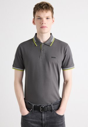 Gray polo shirt with a two-button placket, contrasting yellow and white striped collar and sleeve accents. Features a black logo on the chest.