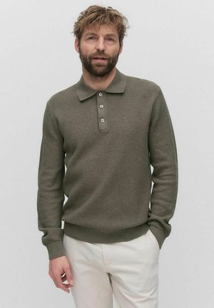 Olijfgroene long-sleeve polo trui met een gestructureerde brei, twee-knopen sluiting en ribbelzoom. Draagt over lichtgekleurde broek.