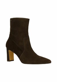 Bottine en suede marron avec un bout pointu, un talon haut et des détails de couture visibles sur les côtés. Texture lisse, design élégant.