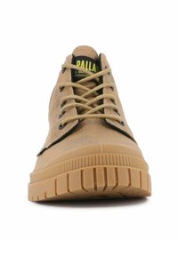 Sneaker in suede beige con punta rotonda, dettagli neri, suola in gomma color tan e lacci beige. Marchio sulla linguetta in giallo. Motivo di battistrada testurizzato.