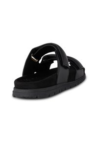 Svarta sandaler med breda klyvda remmar i glatt läder och mjuk mocka, som har en strukturerad sula och minimala metallnålar.