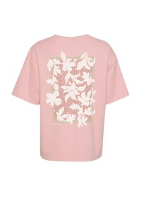 T-shirt rose à manches courtes présentant un motif floral blanc sur un fond carré, avec une bordure vert clair. Fabriqué en coton doux.