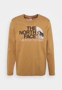 Braunes Langarm-T-Shirt aus Baumwolle mit Rundhalsausschnitt. Verziert mit einem schwarzen grafischen Logo und einem Bergdesign mit Text darunter.