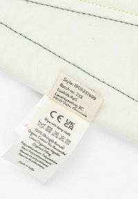 Krém színű pamut párnahuzat hímzett részletekkel. Tartalmaz címkét ápolási utasításokkal, anyaginformációval és eredet adatokkal.