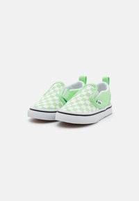 Zapatillas slip-on de cuadro verde y blanco con paneles elásticos en los laterales, cuello acolchado y suela de goma, con un ribete blanco y el logo de Vans.