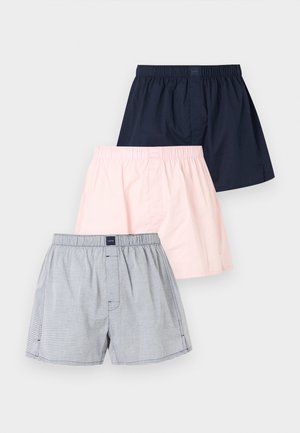 Tre par herre boxershorts med elastisk talje i navy, lyserød og grå stribede mønstre, arrangeret overlappende på en hvid baggrund.