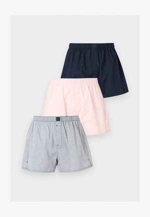 Τρία ζεύγη ανδρικών μποξεράκια με ελαστική μέση σε ναυτικό μπλε, ανοιχτό ροζ και γκρι ριγέ σχέδια, τοποθετημένα επικαλυπτόμενα σε λευκό φόντο.