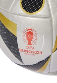 Krimski prikaz bijelog, crnog i zlatnog nogometnog lopte s UEFA Euro 2024 logotipom Njemačke u crvenoj boji.