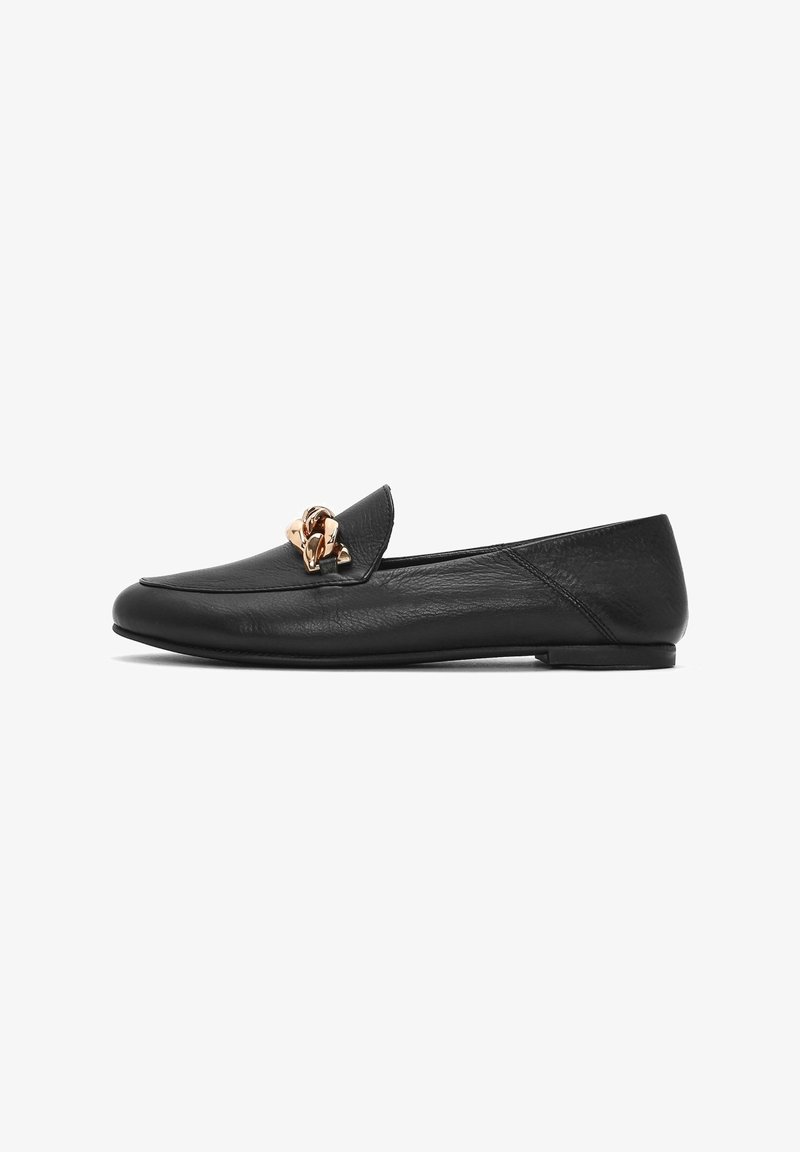 Mocasines de cuero negro con puntera redonda, que cuentan con un acento metálico decorativo en la parte frontal y una suela de goma baja y plana.