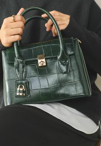 Dark green croc-embossed leather handbag with a structured shape, double handles, and a gold lock accent on the front.