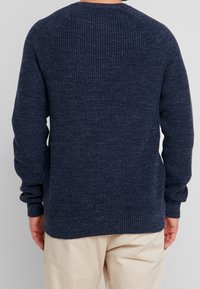 Marineblauer, gestrickter Pullover mit geripptem Muster, Rundhalsausschnitt und langen Ärmeln. Verfügt über Raglanärmel und eine lockere Passform.