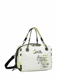 Sac à main en tissu blanc avec des accents noirs et jaunes, présentant un mélange de motifs textuels. Poignées doubles et bandoulière amovible.
