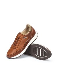 Sneaker in pelle marrone con tomaia testurizzata, design con lacci elasticizzati, suola intermedia bianca e suola in gomma con motivo.