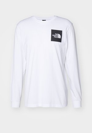 Vit långärmad t-shirt med svart fyrkantig logotyp som säger "The North Face" på övre vänstra bröstet.