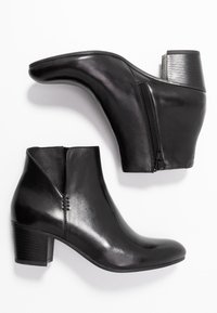 Stivaletti neri in pelle con tacco curvo, zip laterale e design elegante. Presentano una texture liscia e sottili dettagli di cucitura.