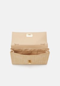 Beige, textuurtas met een gouden sluiting, met een ruime binnenkant en een voering met een subtiel patroon. Geopend zicht, met zicht op de compartimenten.