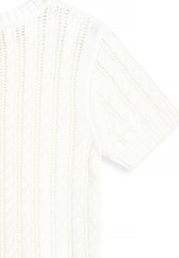 Balts adīts džemperis ar ribotu apkakli, īsām piedurknēm un teksturētām stiegru adatām visā virsmā. Mīksts, viegls materiāls.