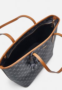 Granatowa torba na ramię z brązowymi skórzanymi uchwytami, z teksturowanym wzorem i zamknięciem na zamek. Wnętrze podszyte ciemnym materiałem z kieszenią na zamek.