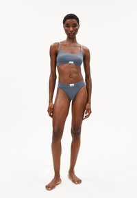 Grijs tweedelig bikini gemaakt van gladde stof. De top heeft dunne bandjes, en de onderkant heeft een low-rise ontwerp met een minimalistisch label.