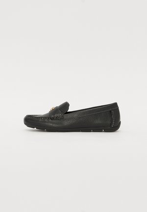 Sapato de couro preto tipo loafer com acabamento texturizado, costura decorativa e um pequeno detalhe de realce na parte da frente. Sola de borracha plana para conforto.