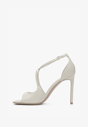 Hellgraue Sandaletten mit hohem Absatz, offenem Zehenbereich und Knöchelriemen. Glatte Lederstruktur, geometrische Ausschnitte und schmaler Absatz.